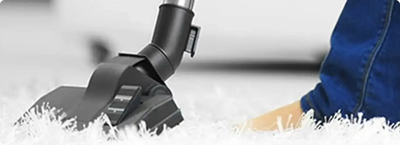 Close-up of a professional vacuuming a white carpet in Kathleen.